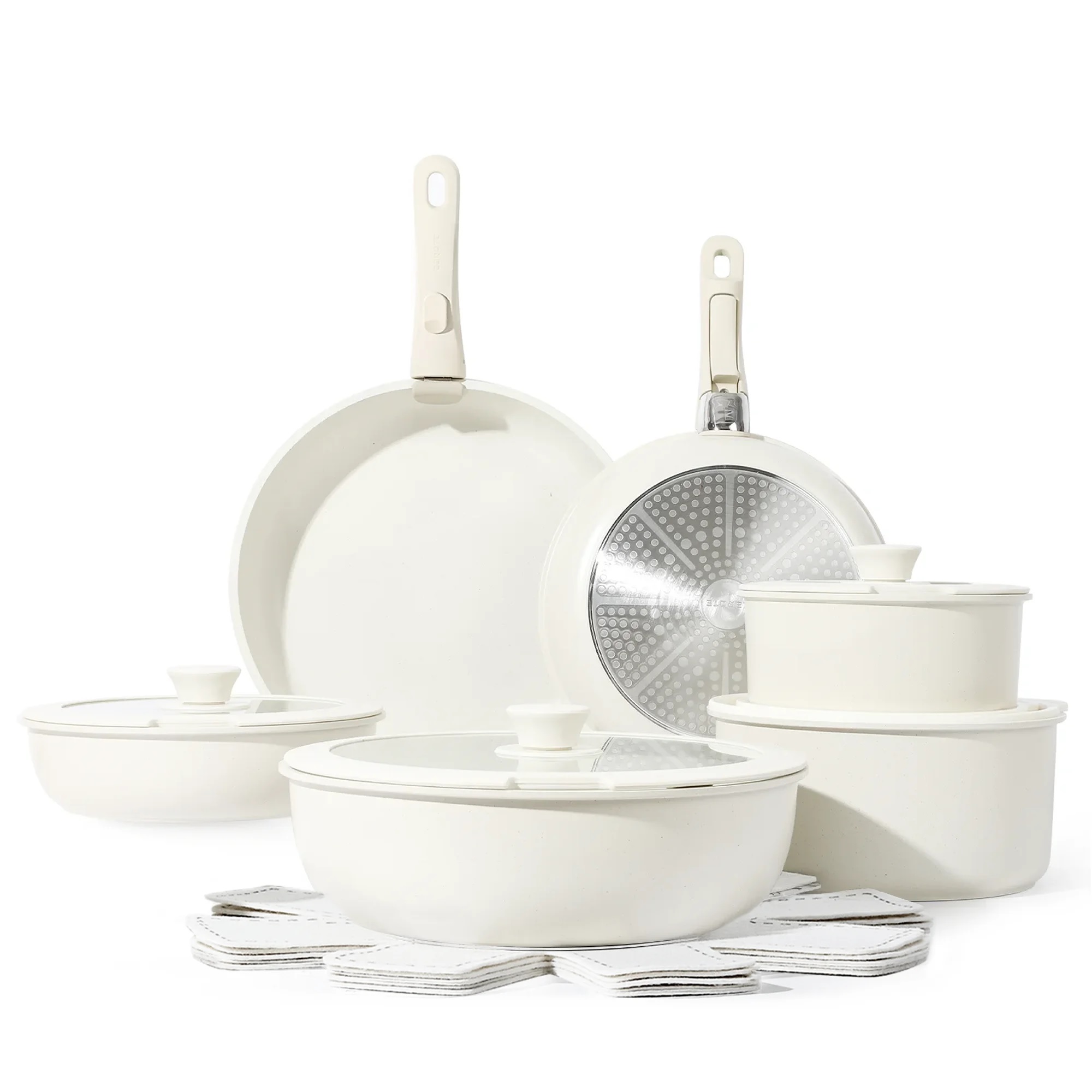 A set of cream-colored ceramic cookware including pans, pots with lids, and coasters.