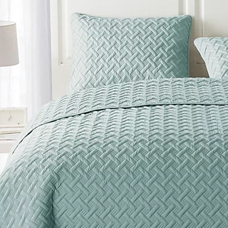 Light blue bedspread set with a textured, geometric pattern, including matching pillow shams.