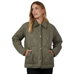 A woman wearing a quilted, olive green jacket with a button front and two side pockets. The jacket features a wave pattern design and a collared neckline.