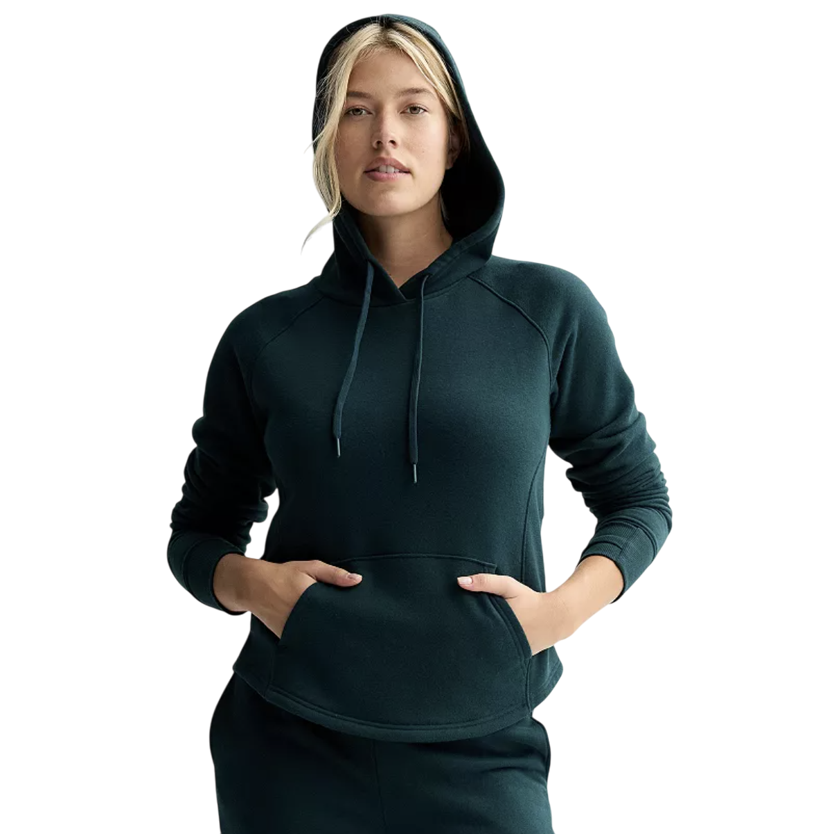 A woman is wearing a dark green hoodie with a front pocket and drawstrings, paired with matching bottom wear.