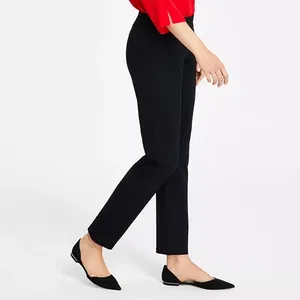 Black ankle-length pants paired with pointed-toe black flats and a red blouse.