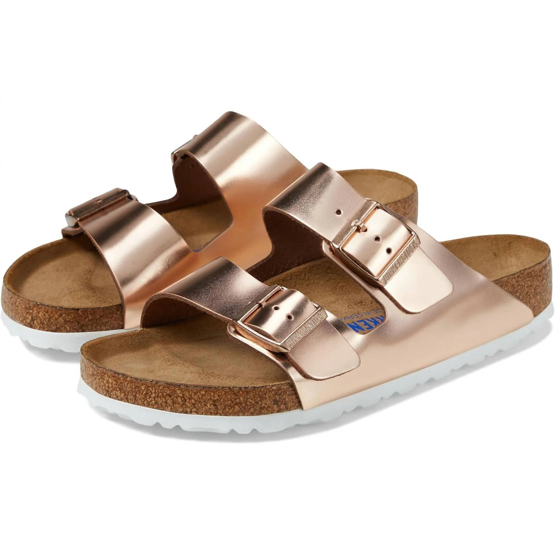 Rose gold sandals with dual straps and buckles, featuring a cork footbed and white sole.