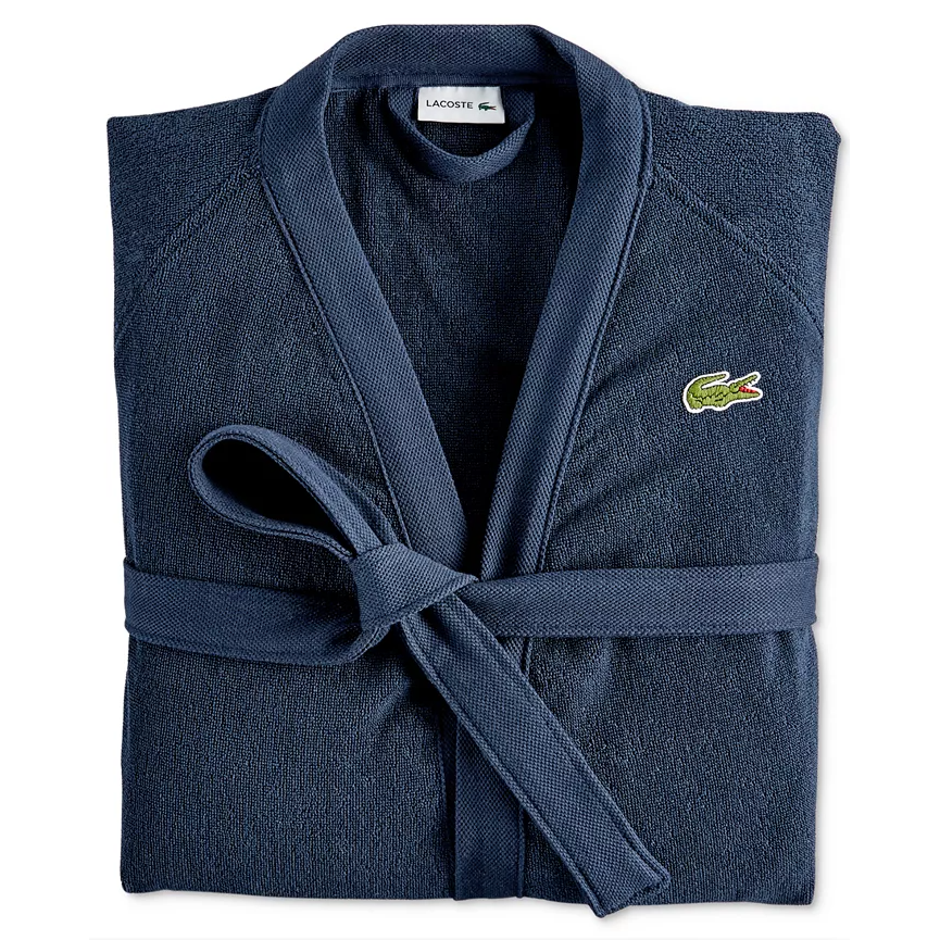 A folded navy blue Lacoste bathrobe with a belt and signature crocodile logo on the chest.