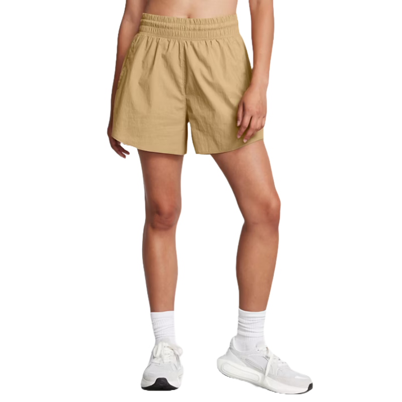 A person is wearing tan athletic shorts with an elastic waistband, paired with white socks and white athletic shoes.
