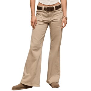 A person is wearing beige flared pants with a brown belt, brown shoes, and several bangles on one wrist. The top is a cropped white shirt.