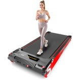 A woman exercises on a compact, red and black treadmill with digital controls. She's wearing a light-colored sports outfit.