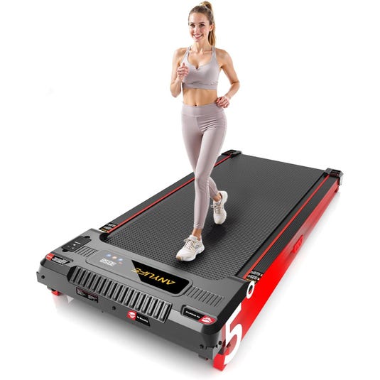 A woman exercises on a compact, red and black treadmill with digital controls. She's wearing a light-colored sports outfit.
