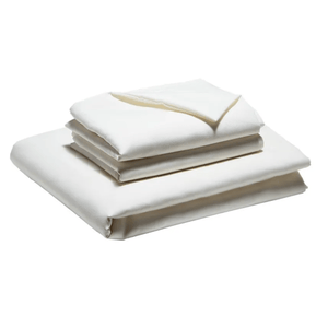 A set of neatly folded, cream-colored bed linens, including a fitted sheet, a flat sheet, and pillowcases.