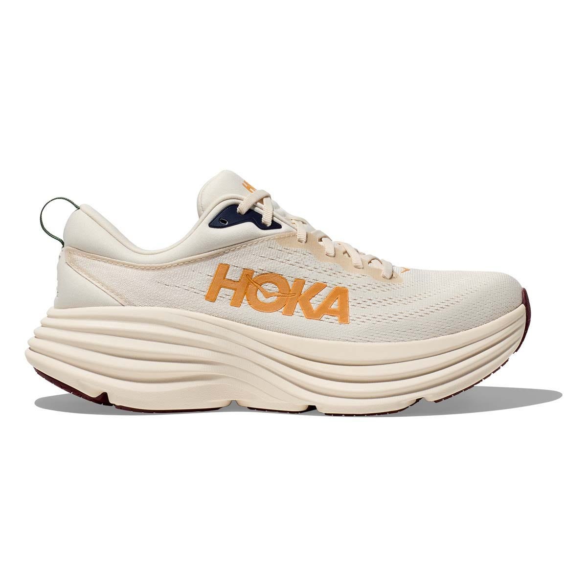 Hoka Men's Bondi 8 Shoes feature a cream color with orange branding, a thick, cushioned sole for maximum support, and a lace-up design, ideal for running and walking.