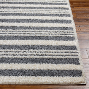 8' x 10' shag area rug with alternating dark gray and white horizontal stripes, featuring a plush, textured surface on a wooden floor.
