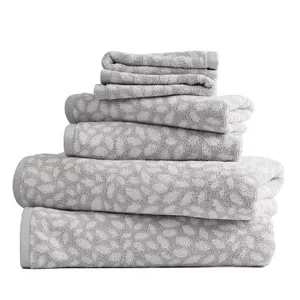 A stack of grey towels with a white floral pattern, including bath towels, hand towels, and washcloths.