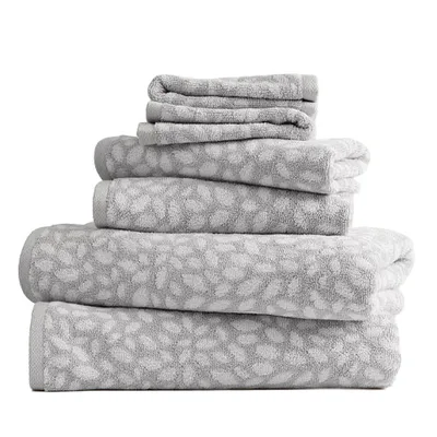 A stack of grey towels with a white floral pattern, including bath towels, hand towels, and washcloths.