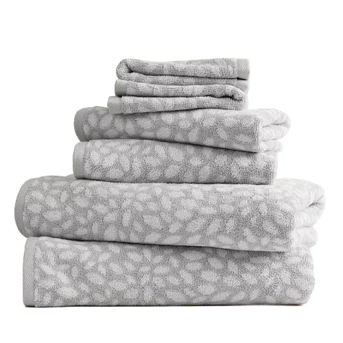 A stack of grey towels with a white floral pattern, including bath towels, hand towels, and washcloths.