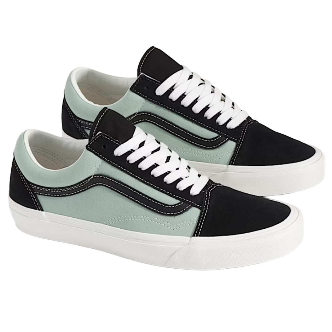 Pair of low-top sneakers featuring a light green canvas body, black suede accents, white laces, and a white rubber sole, with a signature black wave design on the sides.