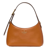 A tan Kate Spade handbag with a curved silhouette and a dark brown adjustable strap.
