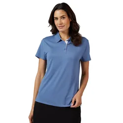 A woman wearing a short-sleeve, blue polo shirt stands against a white background. She has dark hair and appears poised with a slight smile.
