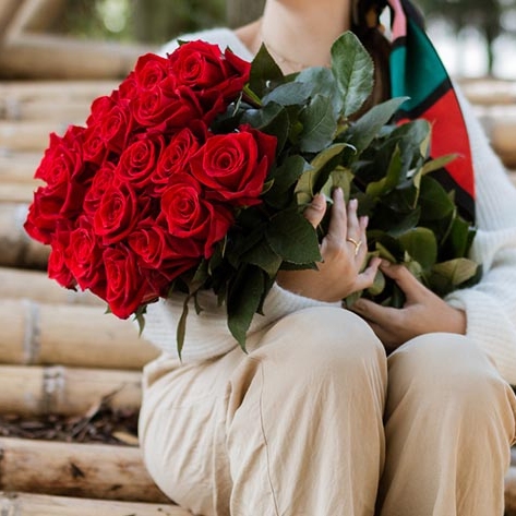 Large bouquet of red roses held by a person.