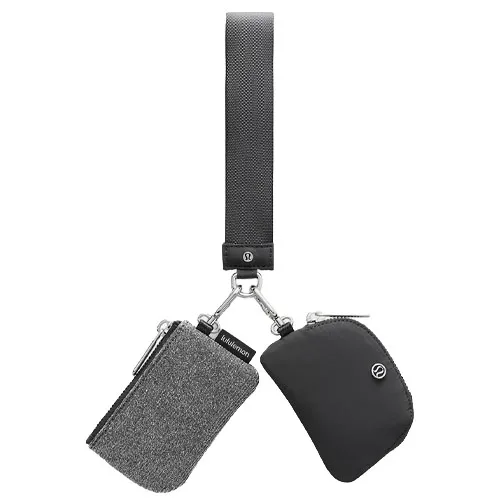A dual-pouch keychain featuring one grey textured pouch and one black pouch connected by clips to a black loop strap, both branded with the Lululemon logo.