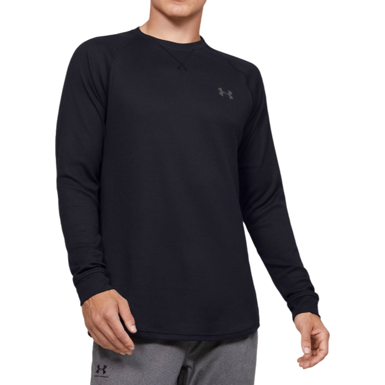 A long-sleeve black crewneck shirt by Under Armour with a waffle-texture fabric and the brand's logo on the upper chest.