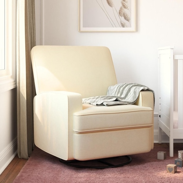 A cream-colored glider chair with a simple, modern design is placed on a pink rug, next to a crib. A gray striped blanket is draped over the armrest, and there are wooden blocks nearby on the floor.