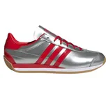 Athletic shoe with a silver body, red accents, and three red stripes on the side. It features a gum-colored sole and red laces.