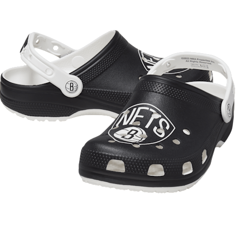 Black and white clogs featuring the Brooklyn Nets logo, with a white adjustable strap and perforated design.
