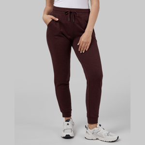 A person wearing dark red sweatpants and white sneakers.