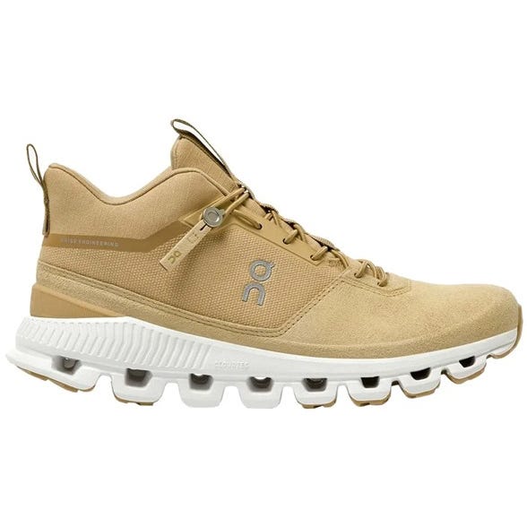 On Running Cloud Hi Women's Shoes feature a beige upper with a white CloudTec sole for cushioning. They have a lace-up design with a pull tab at the back and a logo on the side, offering a stylish and functional design for versatile wear.