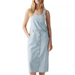 Light blue denim pinafore dress with a front button closure and side pockets, featuring adjustable straps and a chest pocket.