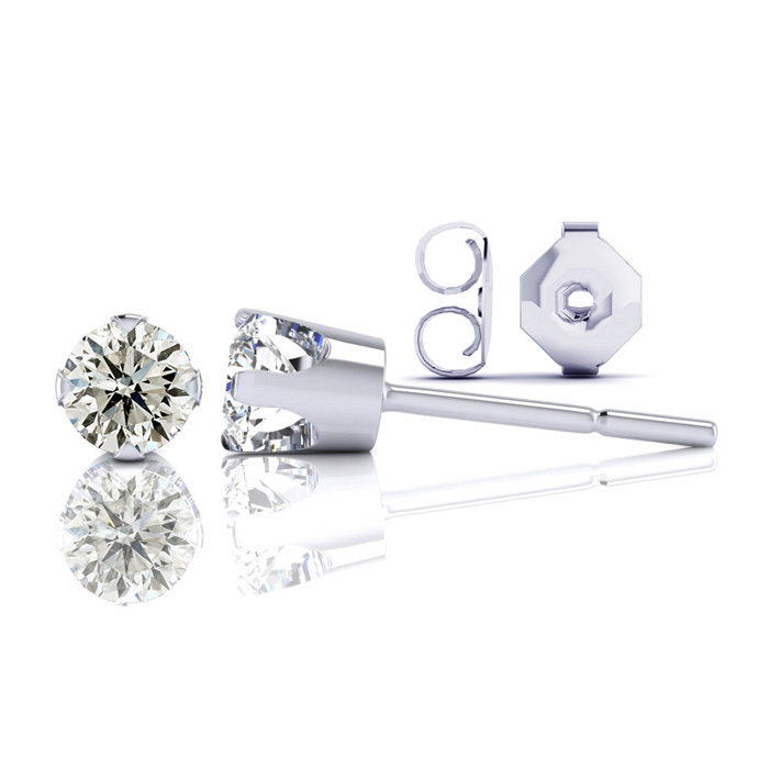 A pair of stud earrings featuring round-cut diamonds set in a four-prong mount with a push-back closure, displayed on a reflective surface.