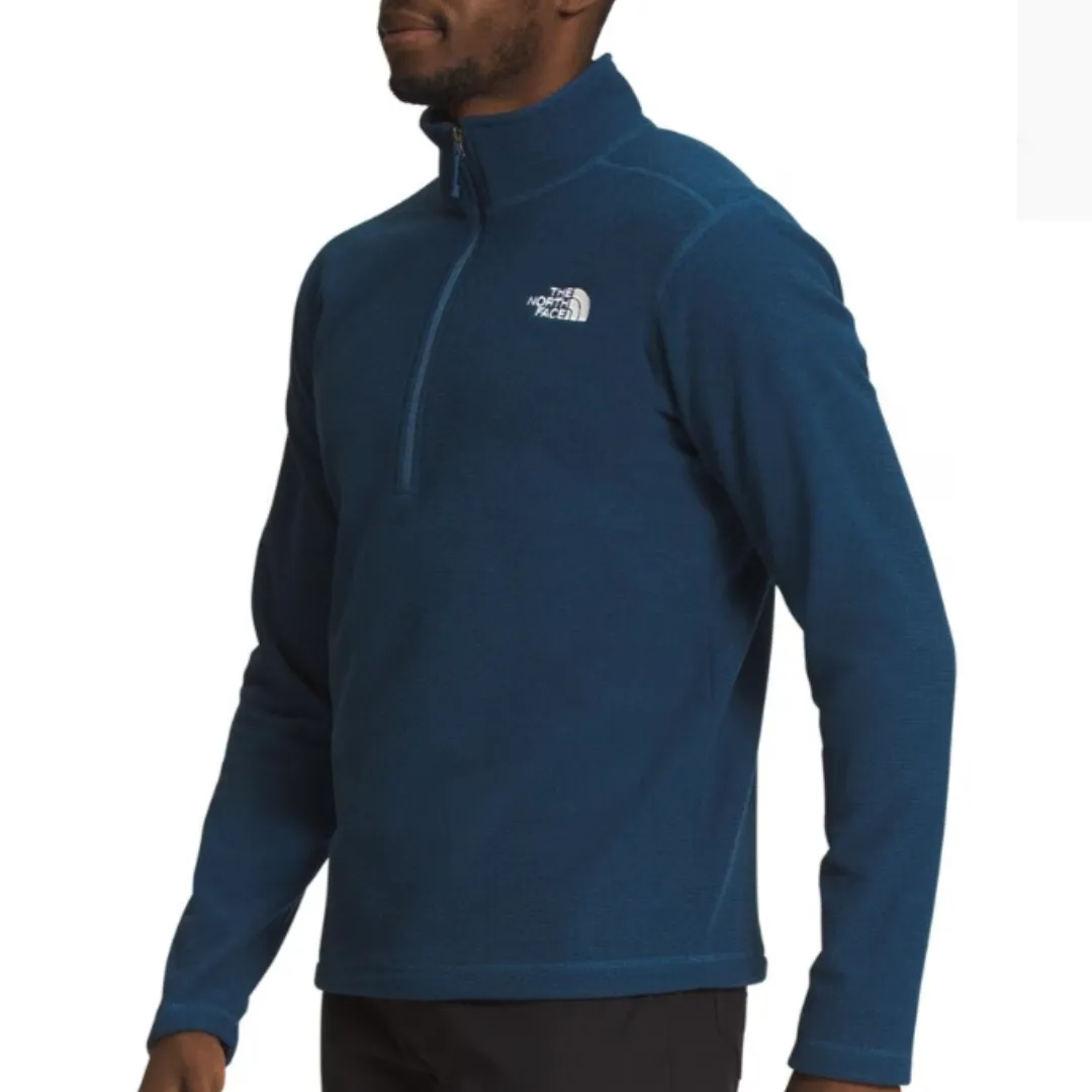 A man wearing a blue half-zip fleece pullover with a logo on the chest.