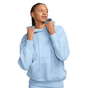 A light blue Nike hoodie featuring a small white logo on the chest, worn by a person with braided hair.