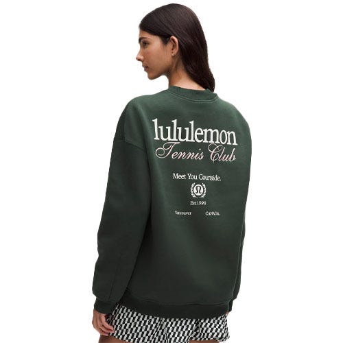 A person wearing a dark green Lululemon sweatshirt with \“Lululemon Tennis Club\“ printed on the back, paired with checkered shorts.