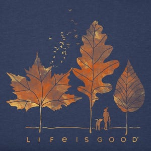 A navy blue T-shirt with a design of three autumn leaves, birds flying away, and a silhouette of a person with a dog, captioned \“Life is good.\“