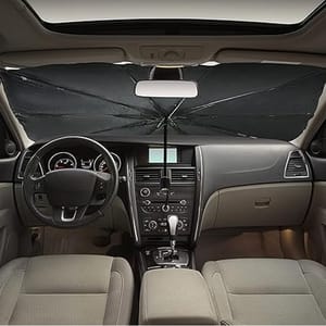 A car sunshade shaped like an umbrella is deployed behind the windshield, blocking sunlight from entering the vehicle's interior.