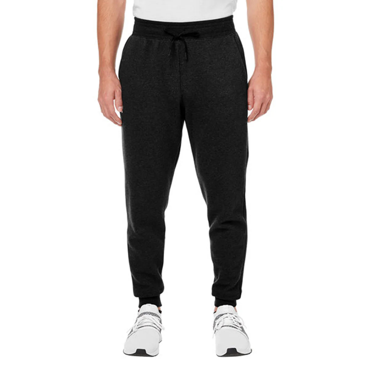 A person wearing black jogger sweatpants paired with white athletic shoes and a white shirt.