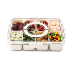A compartmentalized storage container holds various snacks, including dates, strawberries, small limes, nuts, heart-shaped marshmallows, rainbow meringue cookies, and colorful candies.