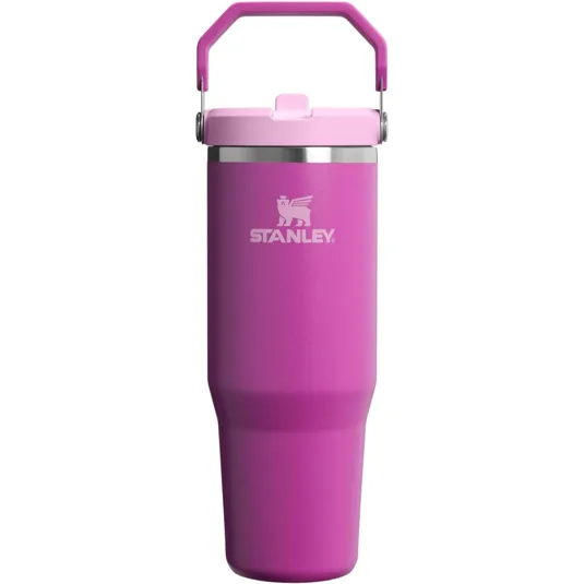 A pink Stanley tumbler with a handle and a flip-top lid, featuring the Stanley logo in white.