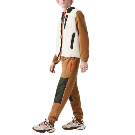 Lacoste Men's ColorBlock Trackpants feature a brown and dark green color scheme, with a colorblock design on the legs. They have ribbed cuffs and an elastic waistband, highlighted by the iconic Lacoste logo on one leg.