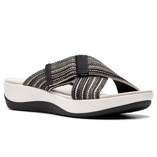 A sandal featuring a black and beige striped crisscross strap on a white platform sole with a wedge heel and black base.