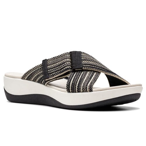 A sandal featuring a black and beige striped crisscross strap on a white platform sole with a wedge heel and black base.