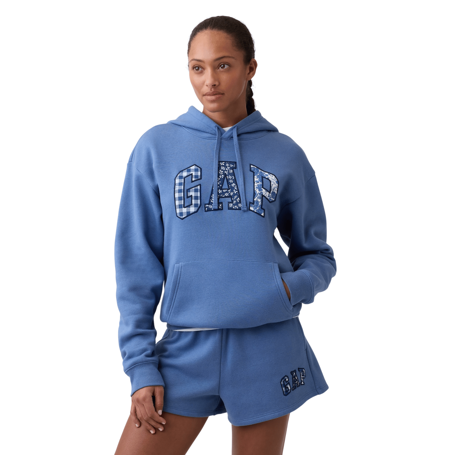 A person is wearing a blue GAP hoodie and matching shorts with the GAP logo in patterned letters.