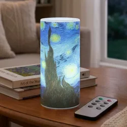 A cylindrical lamp with a \“Starry Night\“ design sits on a table next to a remote control. The room features warm lighting, a cozy sofa, and a window view of a moonlit night.