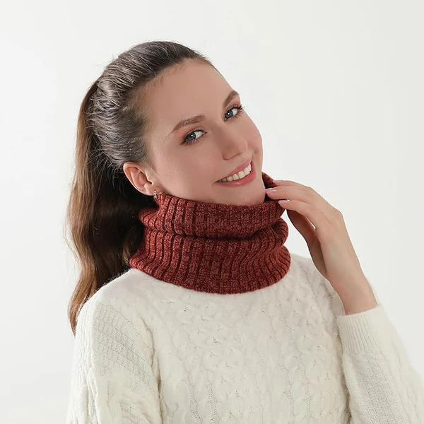 Woman wearing a white cable-knit sweater and a rust-colored turtleneck collar.