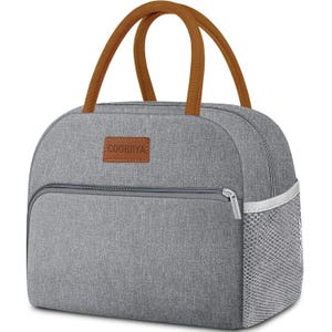 A gray, insulated lunch bag with brown handles, a front zippered pocket, and a side mesh pocket. The brand name \“COOBIIYA\“ is on a leather-like patch.