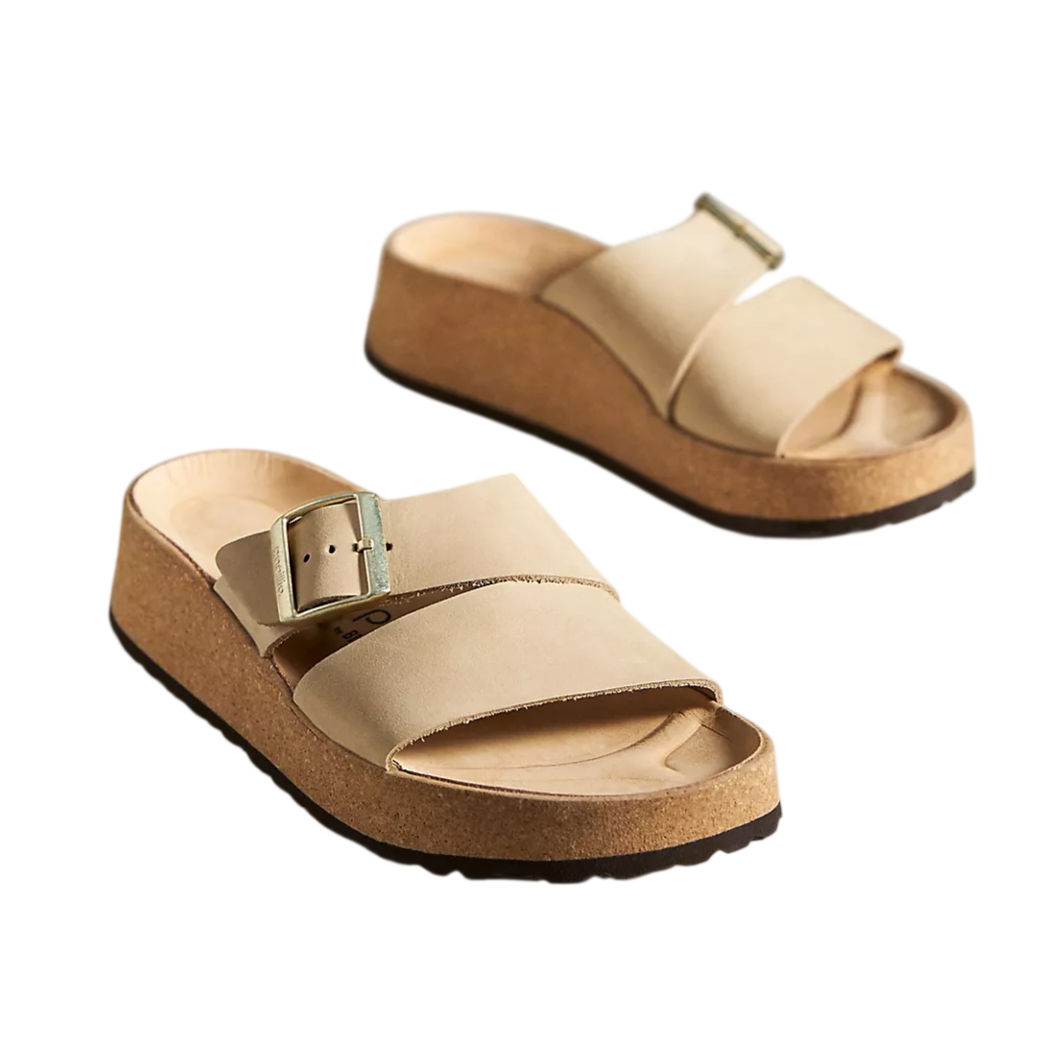 Beige platform sandals with wide straps, a buckle, and a cork-style sole.