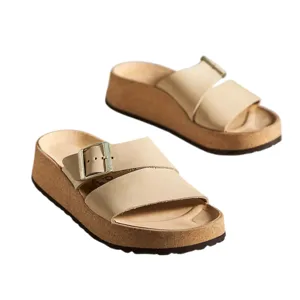 Beige platform sandals with wide straps, a buckle, and a cork-style sole.
