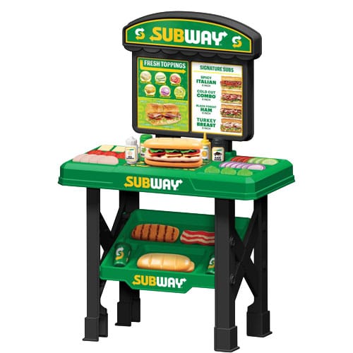 Toy Subway sandwich shop playset with a green countertop, fake food items like subs and toppings, and a menu board displaying sandwich options.