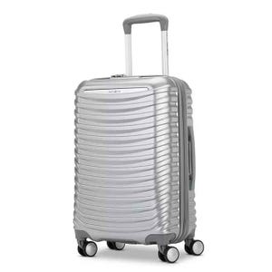 Silver Samsonite carry-on spinner featuring a textured, ribbed design with four multidirectional wheels, a telescopic handle, and a side handle for easy transport.