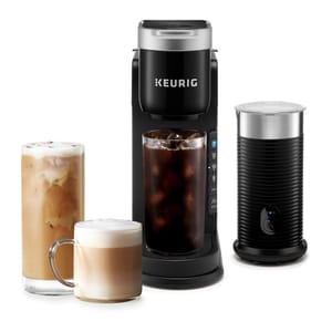 Keurig coffee maker with an iced coffee and a latte beside it, accompanied by a milk frother.
